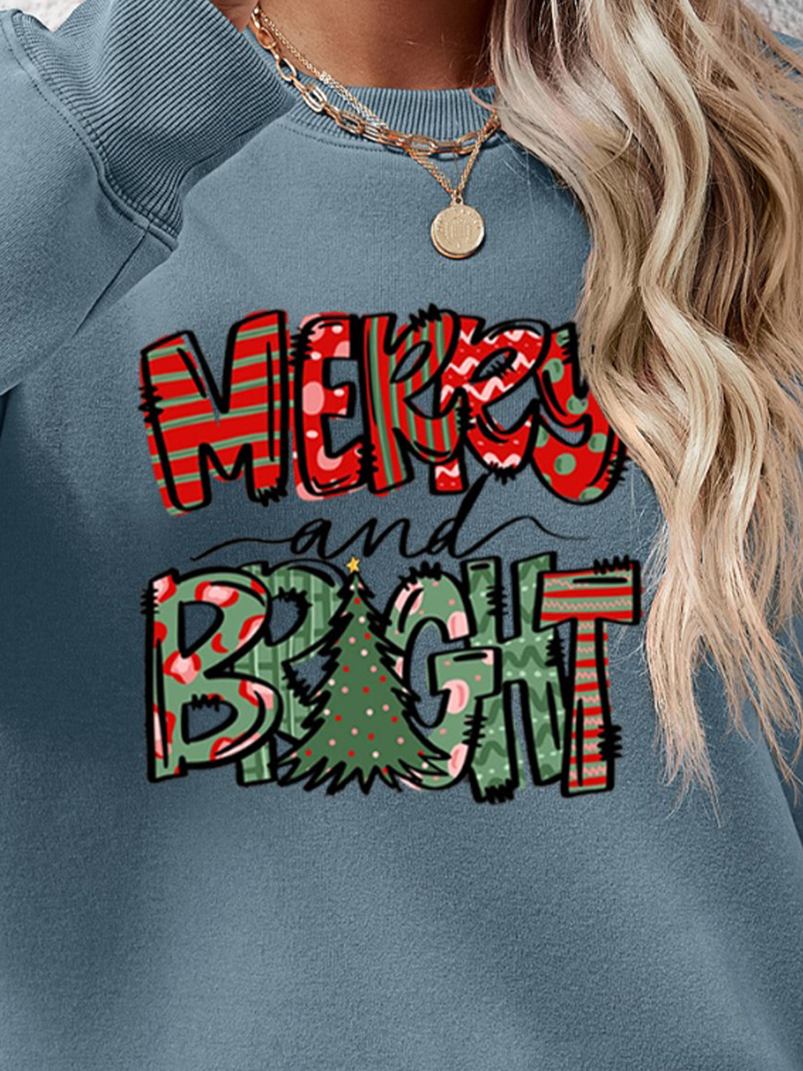 Misty Blue crewneck sweatshirt with Merry and Bright graphic and Christmas tree detail.