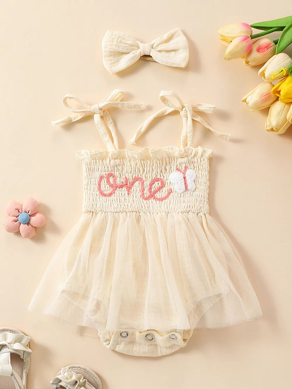 Apricot smocked baby bodysuit with tulle skirt and matching headband.