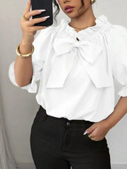 White ruffled bow sleeve blouse with cinched neckline and puff sleeves.