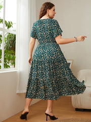 Emerald floral midi dress in deep teal with flutter sleeves and tiered skirt.