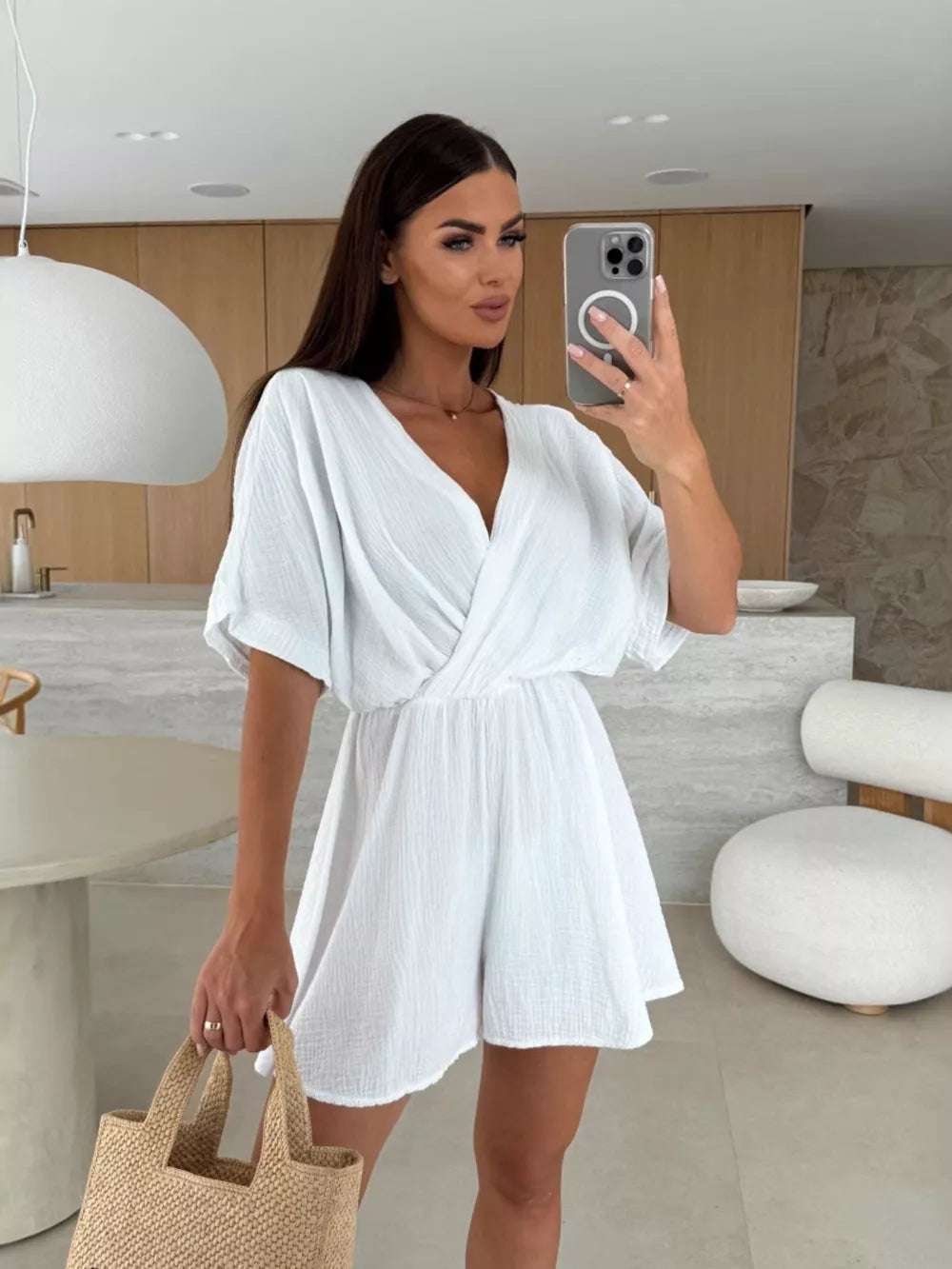 White twist-detail V-neck romper with dolman sleeves and cinched waist, casual style.