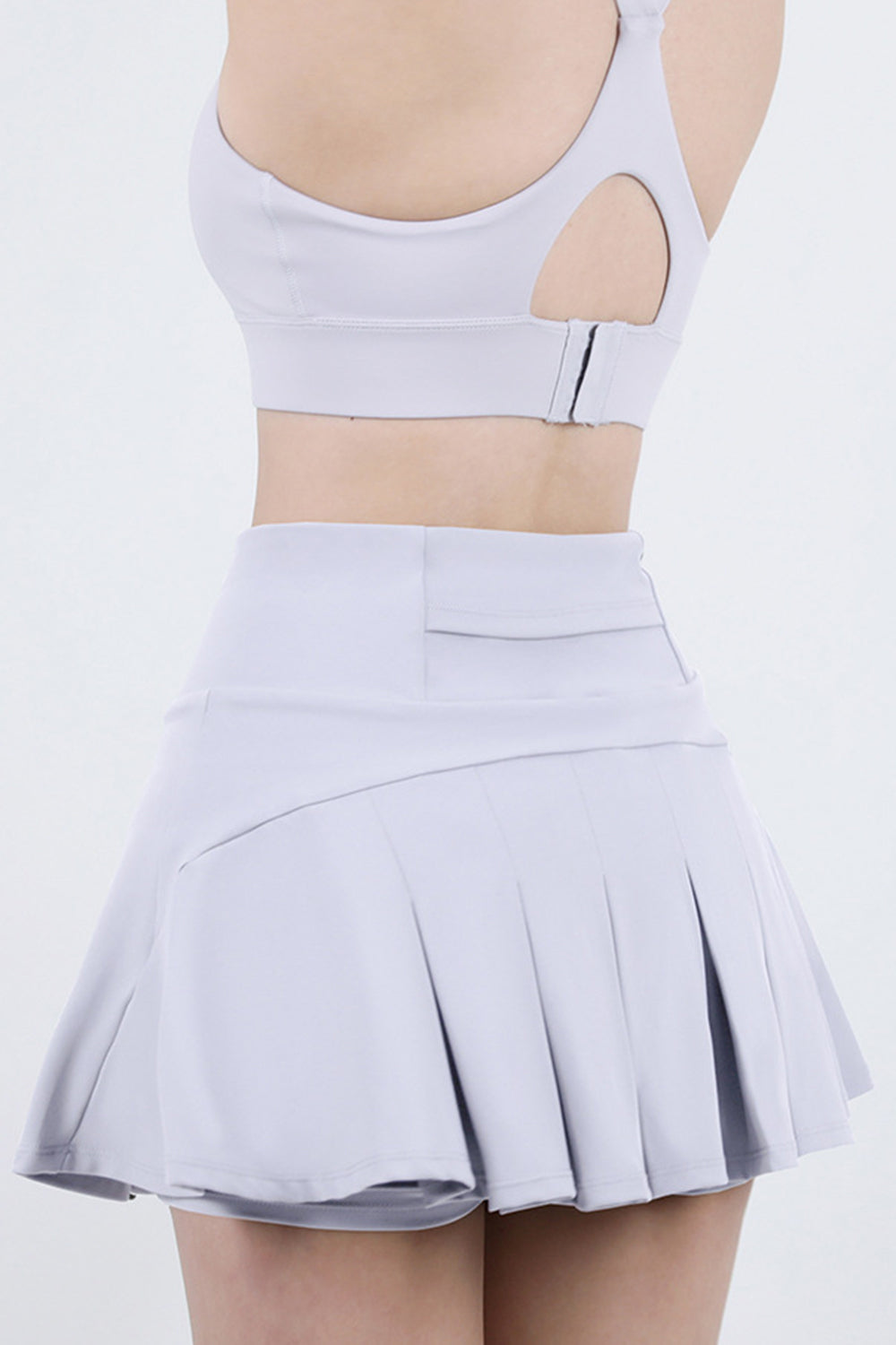 Light gray pleated active skort with a high waist and flared hem.