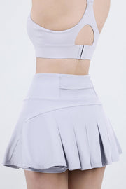 Light gray pleated active skort with a high waist and flared hem.