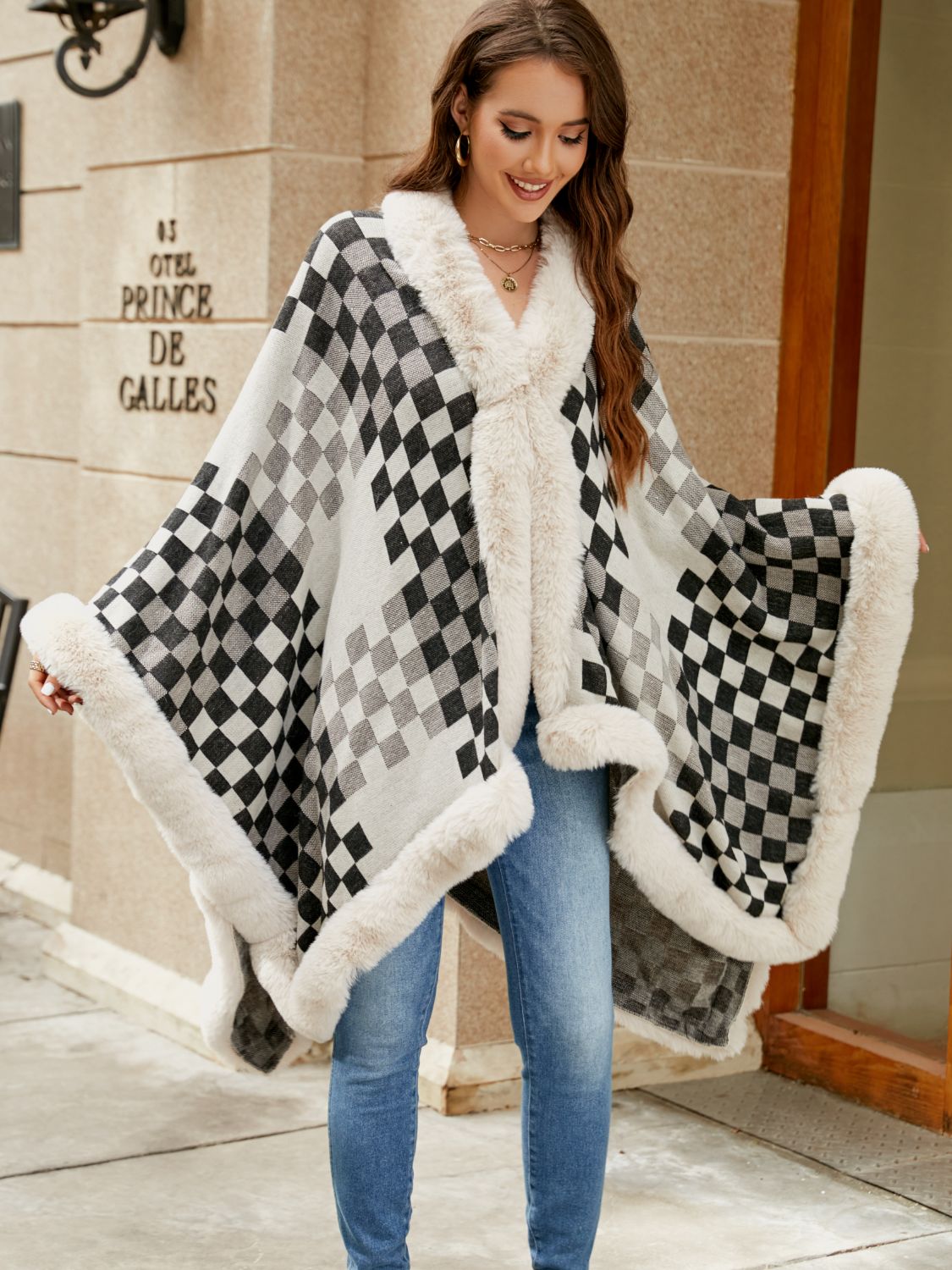 Diamond checkered poncho with faux fur trim in ivory and charcoal, open front style.