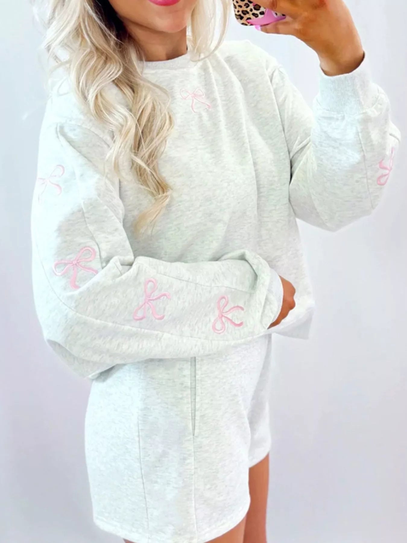 Gray loungewear set with pink bow embroidery on sweatshirt sleeves and chest.