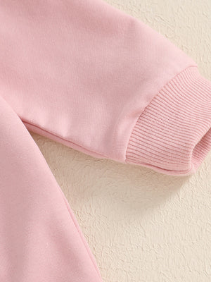 Pink cotton baby outfit with ribbed cuffs and bunny applique detail.