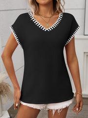 Black knit V-neck sweater top with white contrast trim on neckline and sleeves.