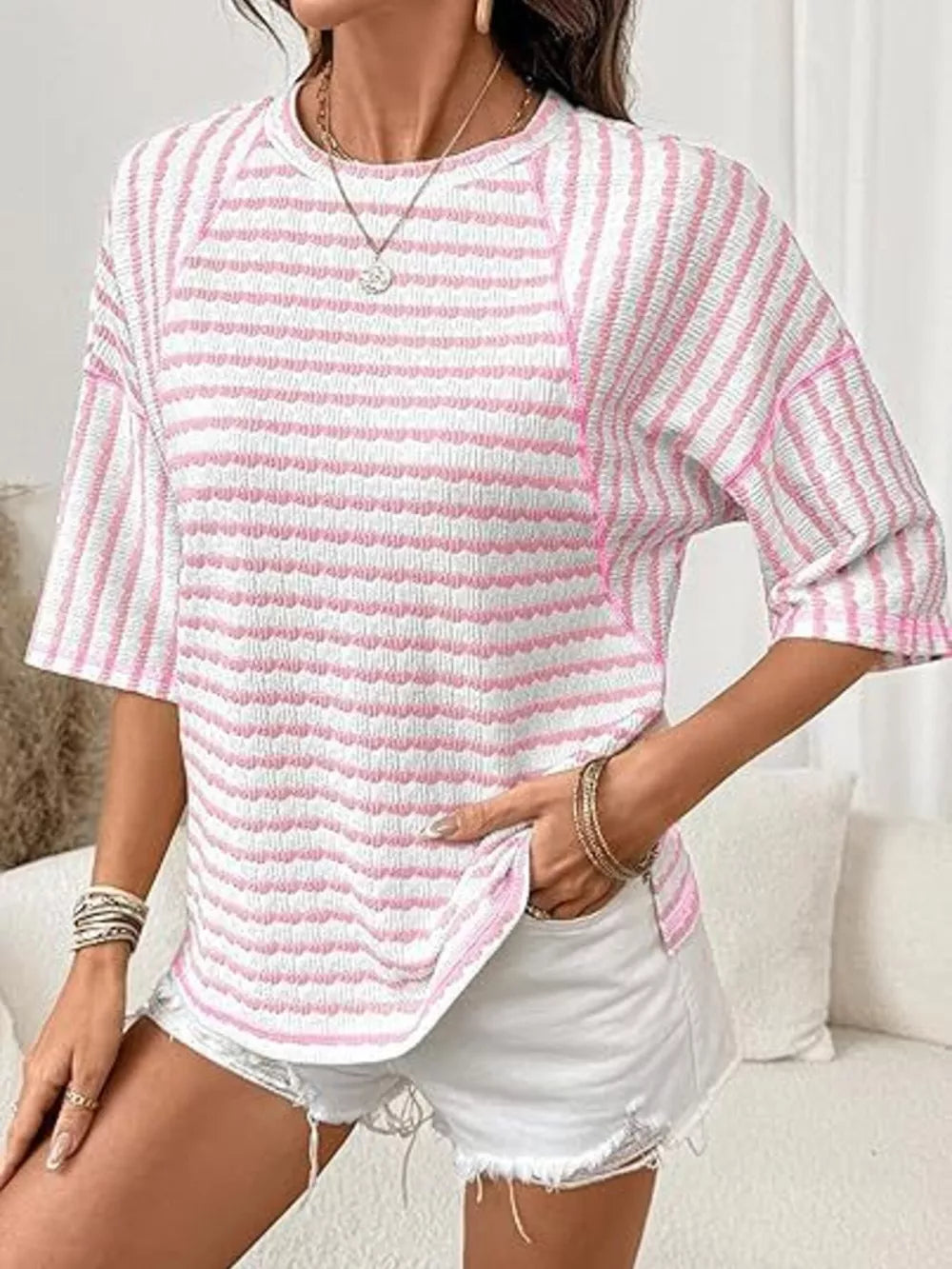 Pink and white wavy stripe knit t-shirt with relaxed fit and crew neck.