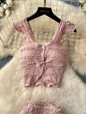 Pink textured two-piece set with ruffled details and button front crop top