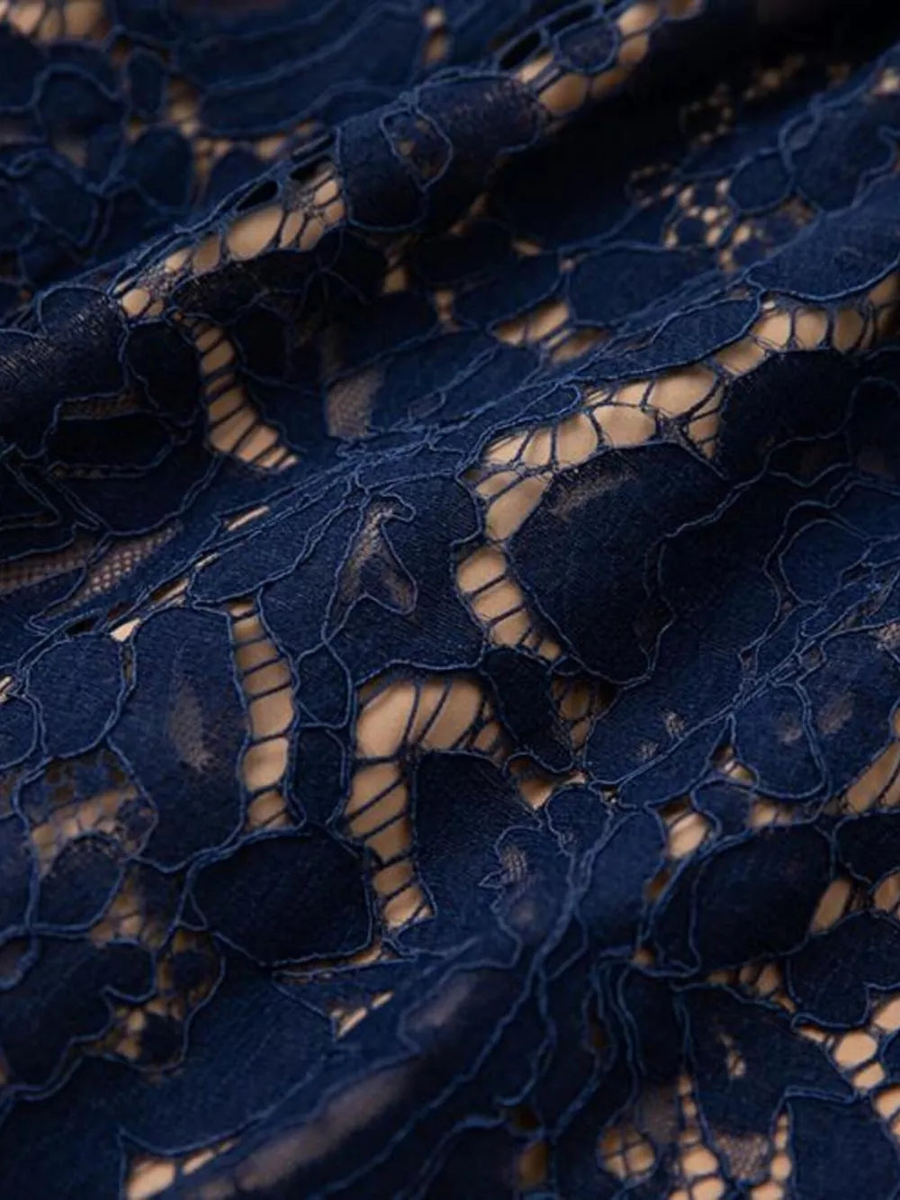 Elegant navy lace midi dress fabric detail with floral pattern and nude lining.