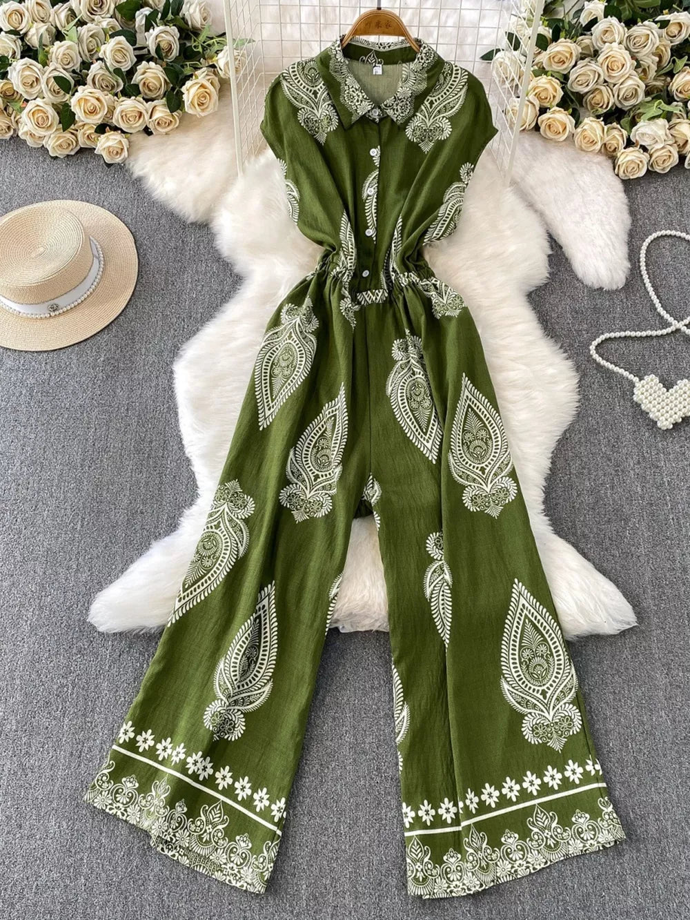 Green buttoned wide leg romper with white paisley print and collared neckline.