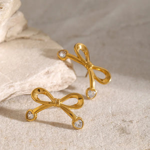 Gold cubic zirconia bow stud earrings with heart-shaped stones