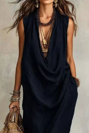 Black cowl neck midi dress with pockets and layered necklaces.