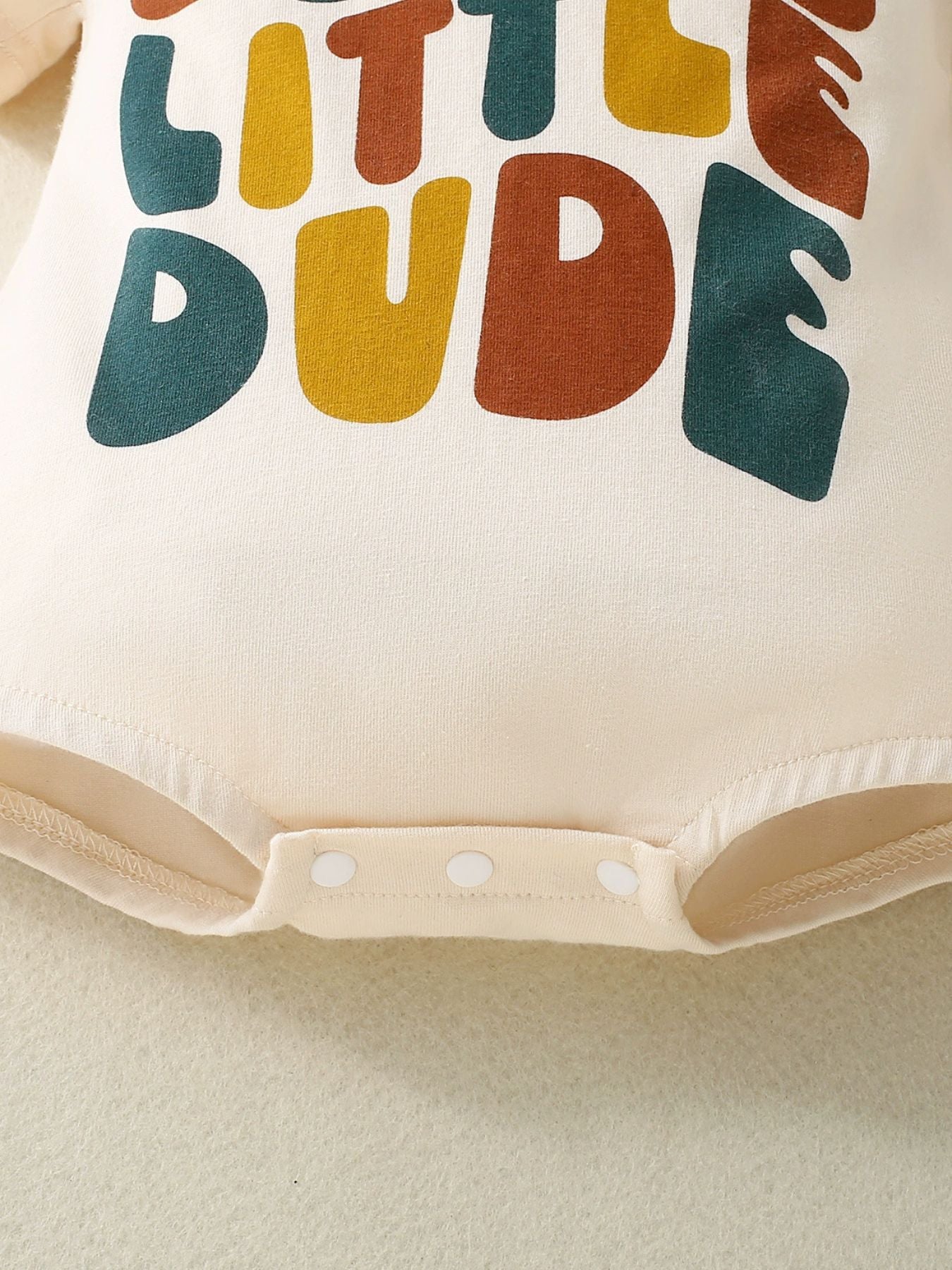 Beige baby bodysuit with colorful "Little Dude" graphic and snap closure