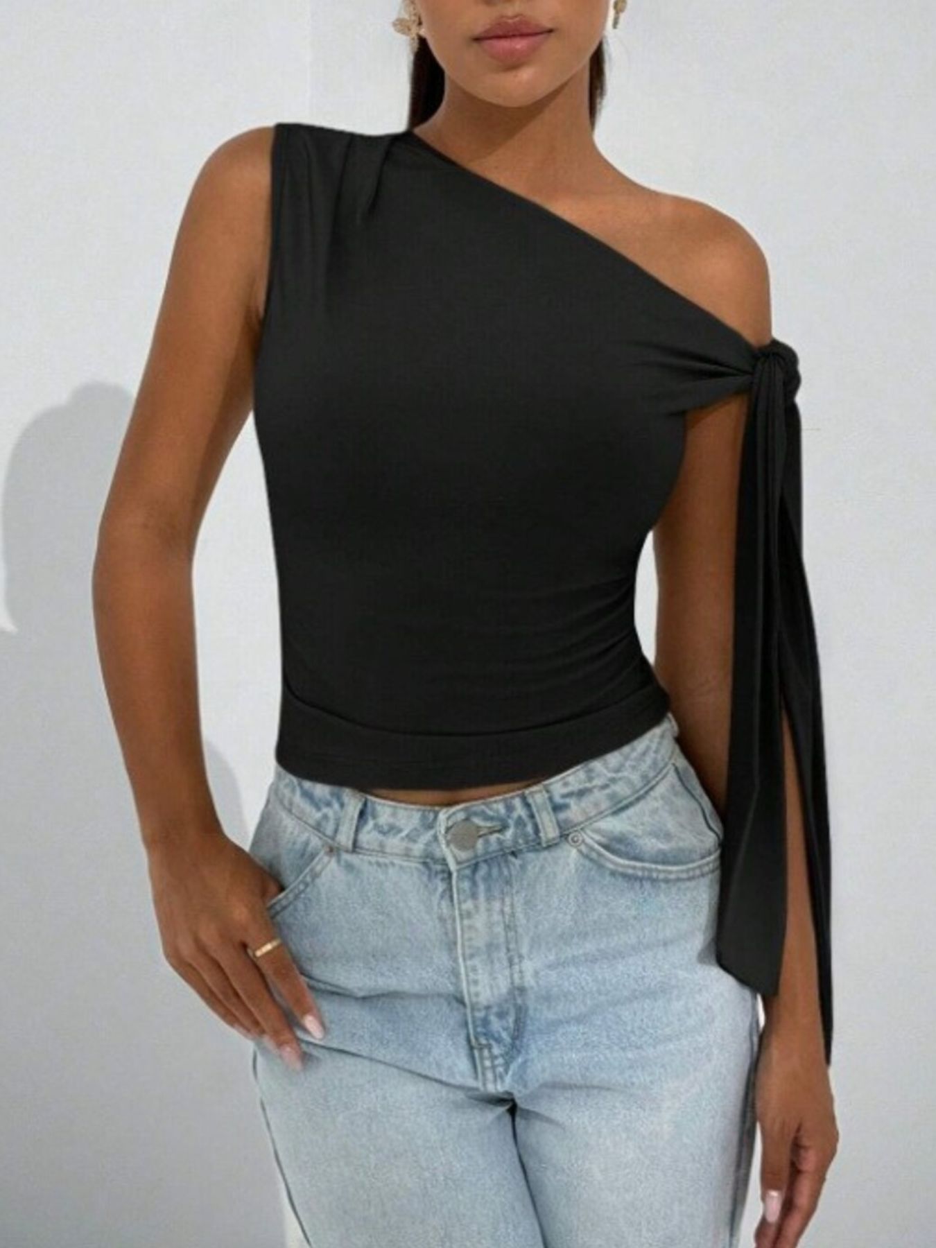 Black asymmetrical tie detail cropped blouse with one sleeve and tie detail.