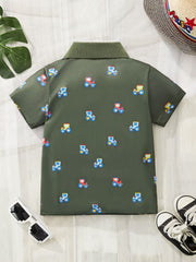 Childrens green short sleeve polo shirt with allover tractor print and ribbed collar.