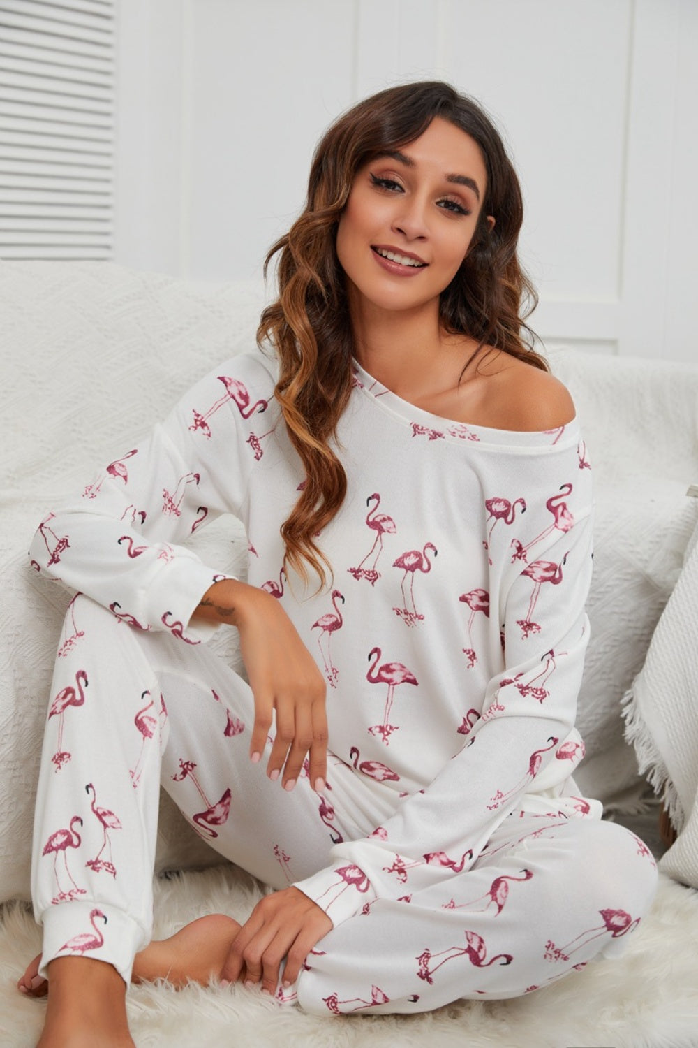 White flamingo print off-shoulder lounge set with long sleeves and pants.