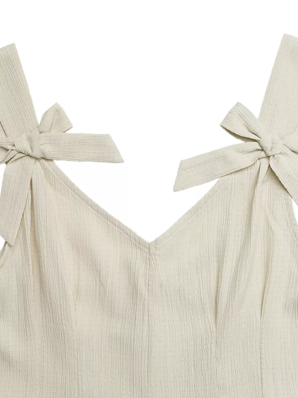 Cream textured romper with V-neck and bowknot shoulder straps