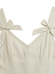 Cream textured romper with V-neck and bowknot shoulder straps