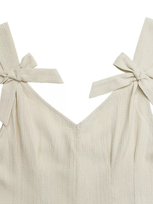 Cream textured romper with V-neck and bowknot shoulder straps