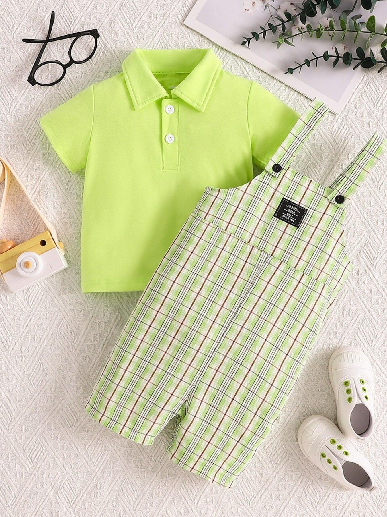 Children's lime green polo shirt and plaid overalls set with adjustable straps.