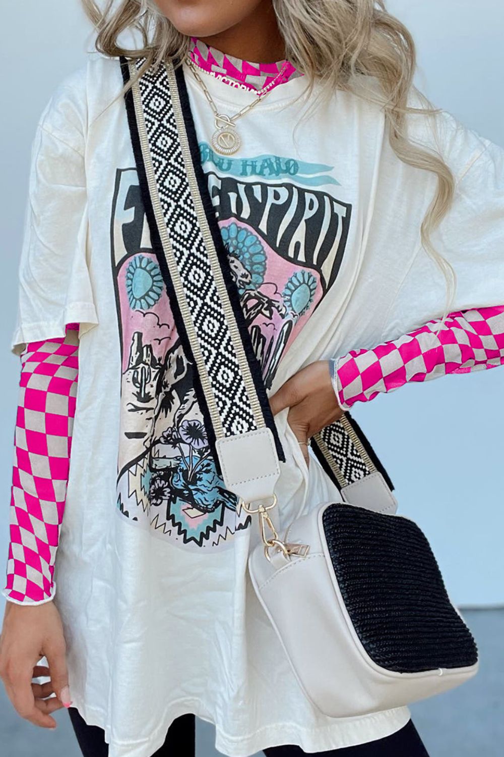 White graphic tee with pink checkered mesh long sleeve shirt underneath.