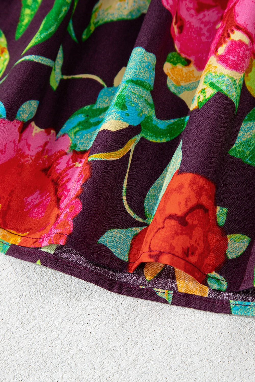 Embroidered floral babydoll blouse in floral print with a ruffled hem detail.
