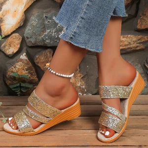 Gold sequined wedge sandals with double straps and an orange wedge sole.