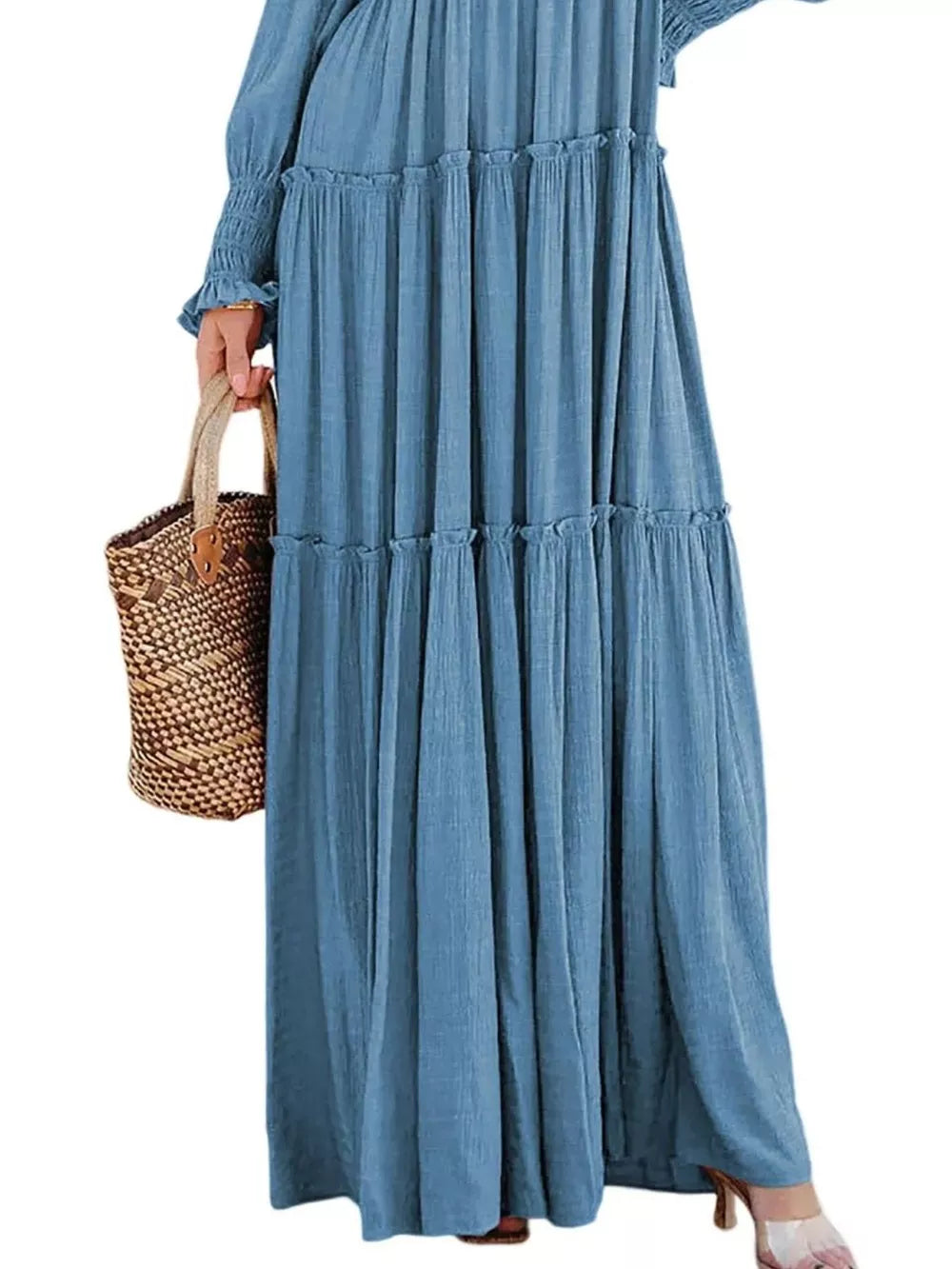 Blue smocked v-neck tiered maxi dress with ruffled details and long sleeves.