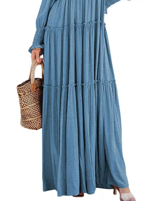 Blue smocked v-neck tiered maxi dress with ruffled details and long sleeves.