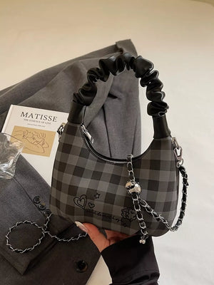 Black checkered mini crossbody bag with ruched handle and chain strap.