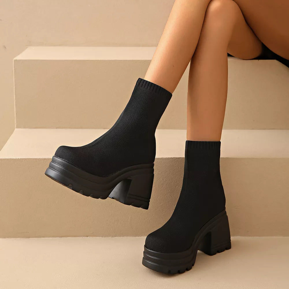 Black knit ankle boots with round toe and chunky platform heel.