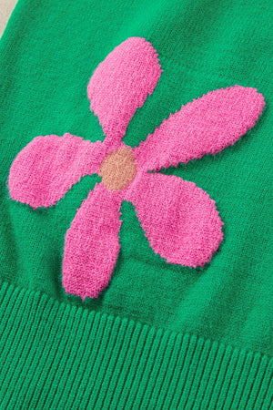 Green knit sweater with a pink floral applique and ribbed hem.
