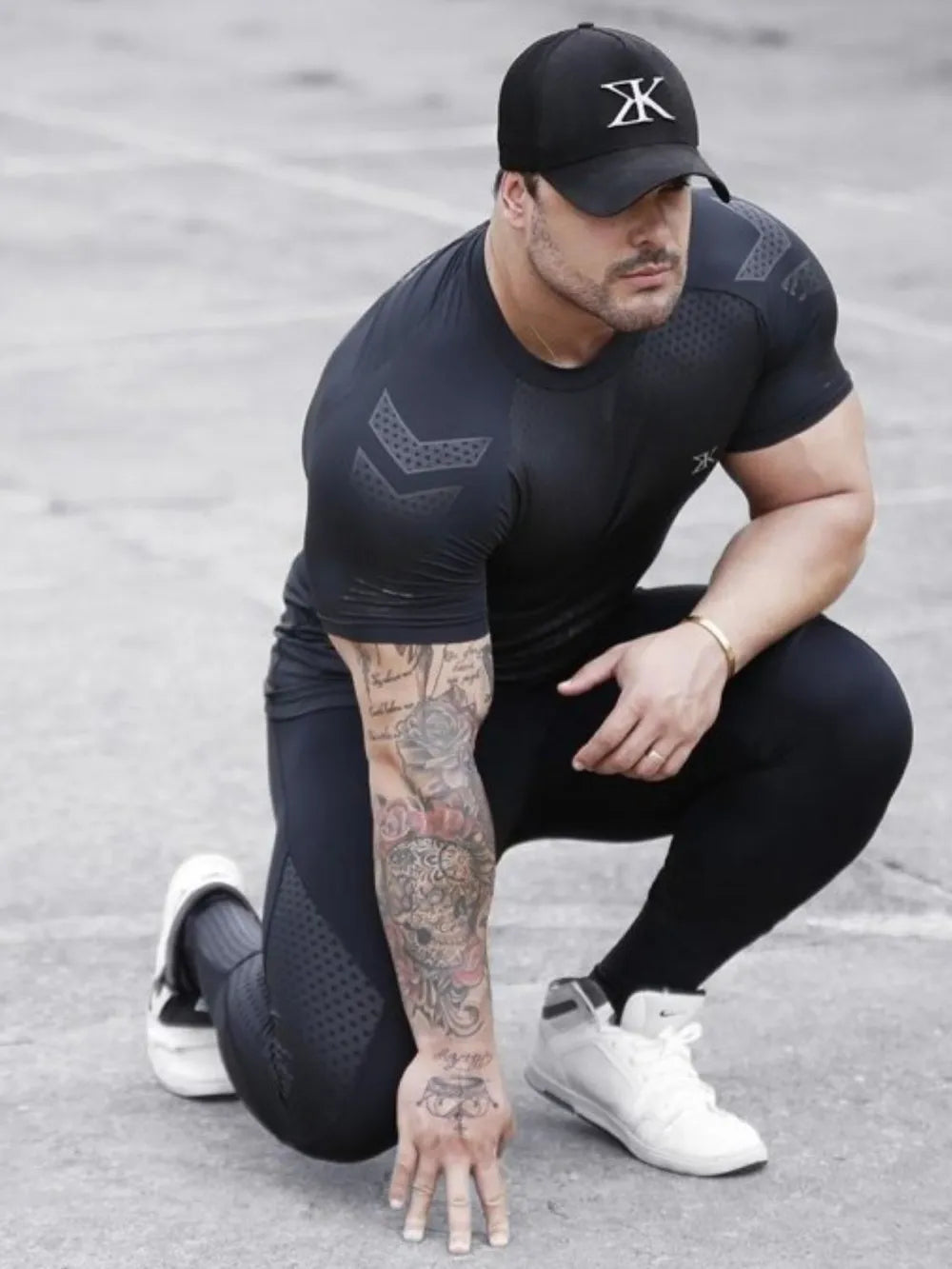 Black performance mesh sculpt tee with chevron detail on shoulders and sleeves.