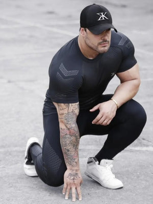 Black performance mesh sculpt tee with chevron detail on shoulders and sleeves.