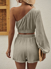 Textured one-shoulder crop top and cuffed shorts set in beige.