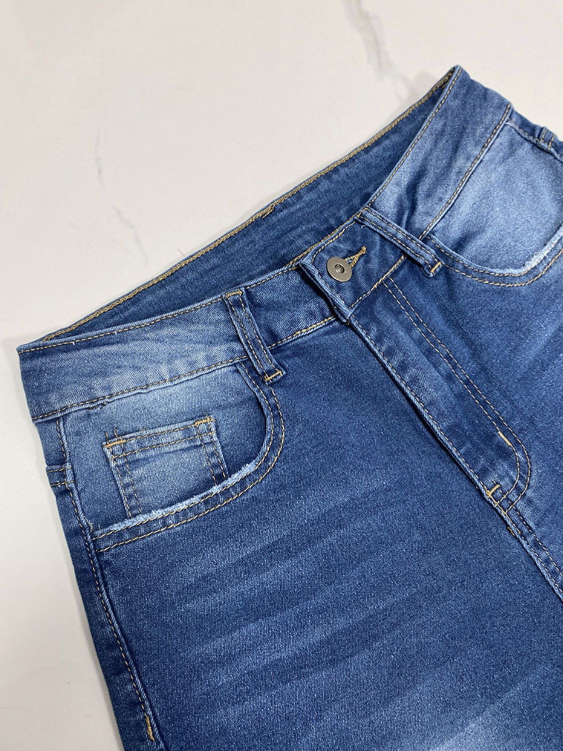 Medium wash wide-leg denim jeans with button fly and contrast cuff detail.
