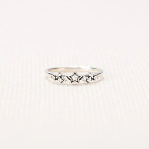 Silver band ring with a celestial cluster of stars and small stones.