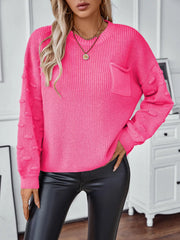 Hot pink knit sweater with crewneck, chest pocket, and textured sleeve details.