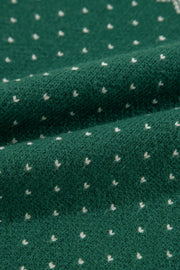 Dark green knit sweater with a white snowflake Fair Isle pattern.