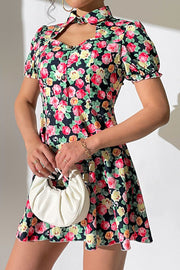 Floral mini dress with keyhole neckline, puff sleeves, and button front.