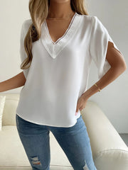 White lace-trimmed V-neck cape sleeve blouse made of 100% polyester.
