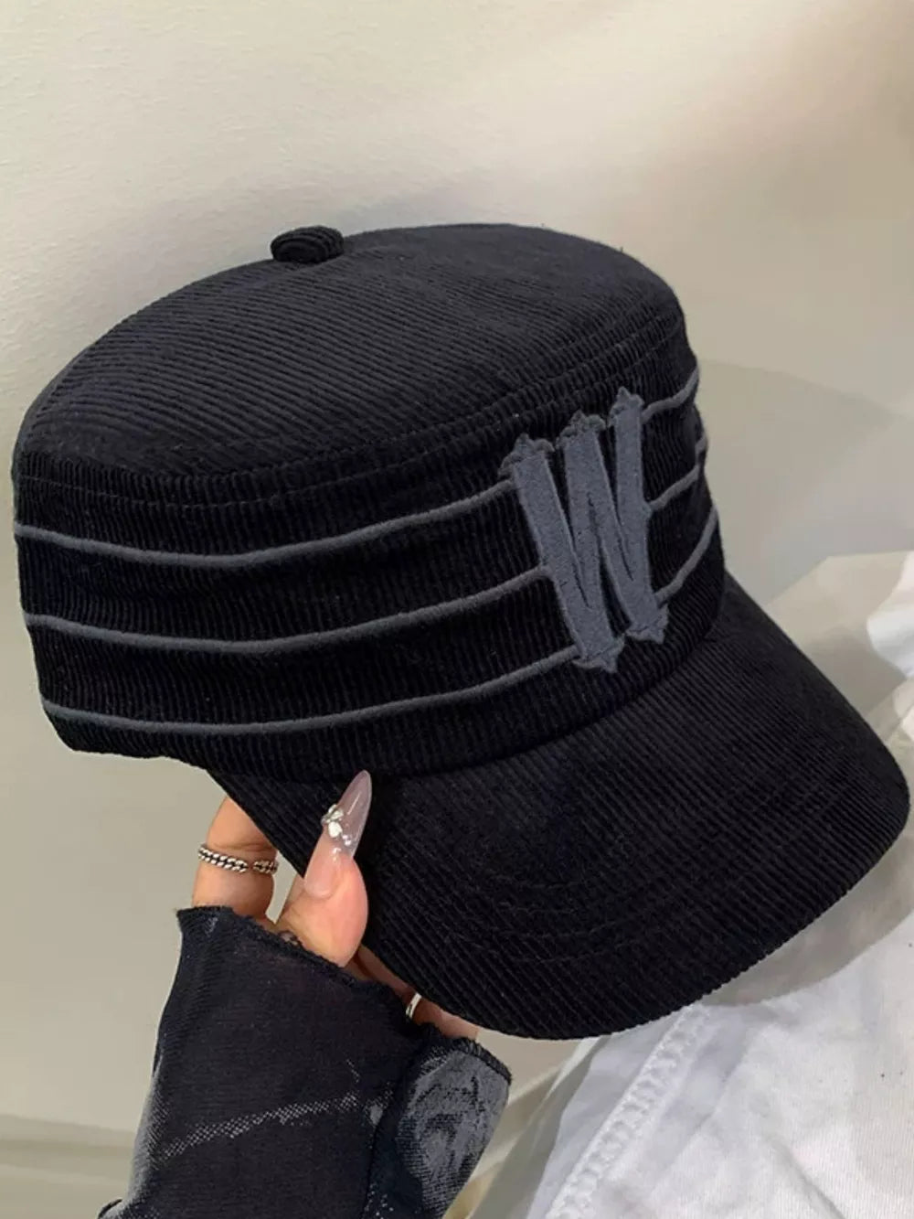 Black corduroy baseball cap with striped detail and embroidered 'W