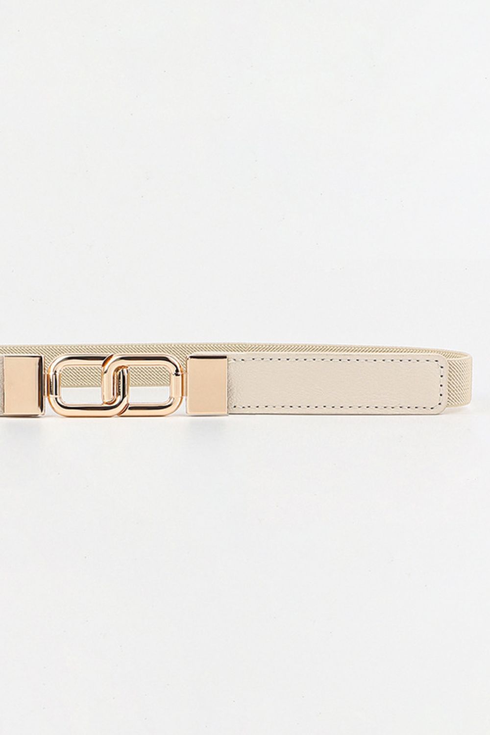 Cream elastic belt with linked gold rectangle buckle and faux leather detail.
