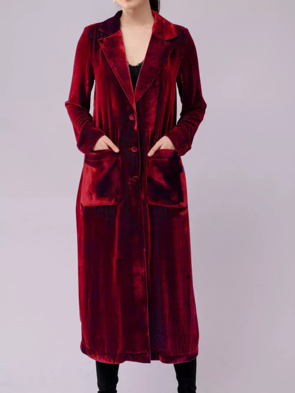 Burgundy velvet longline trench coat with button front and patch pockets.