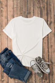 White t-shirt with twisted hem, cuffed sleeves, and crew neck, styled with distressed jeans and leopard print sneakers.
