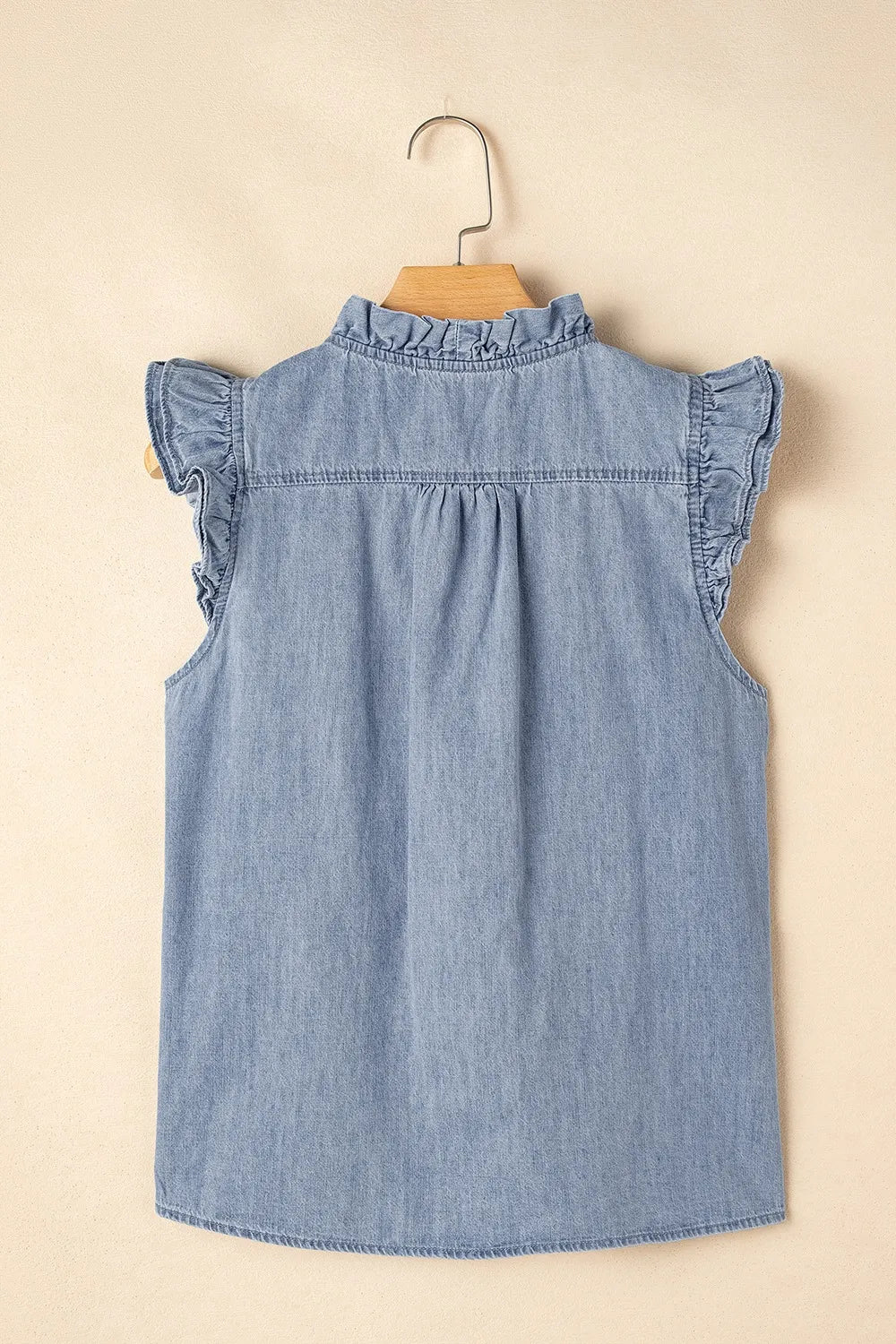 Chambray sleeveless blouse with ruffled neckline and sleeves.