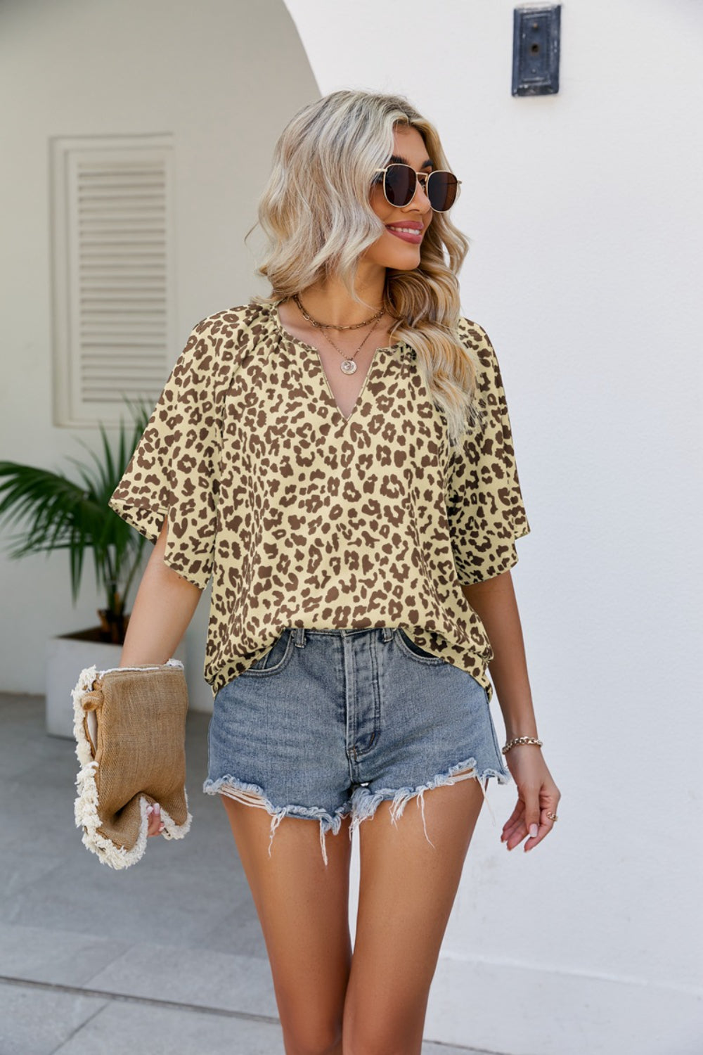 Olive leopard print v-neck blouse with short sleeves and a relaxed fit.