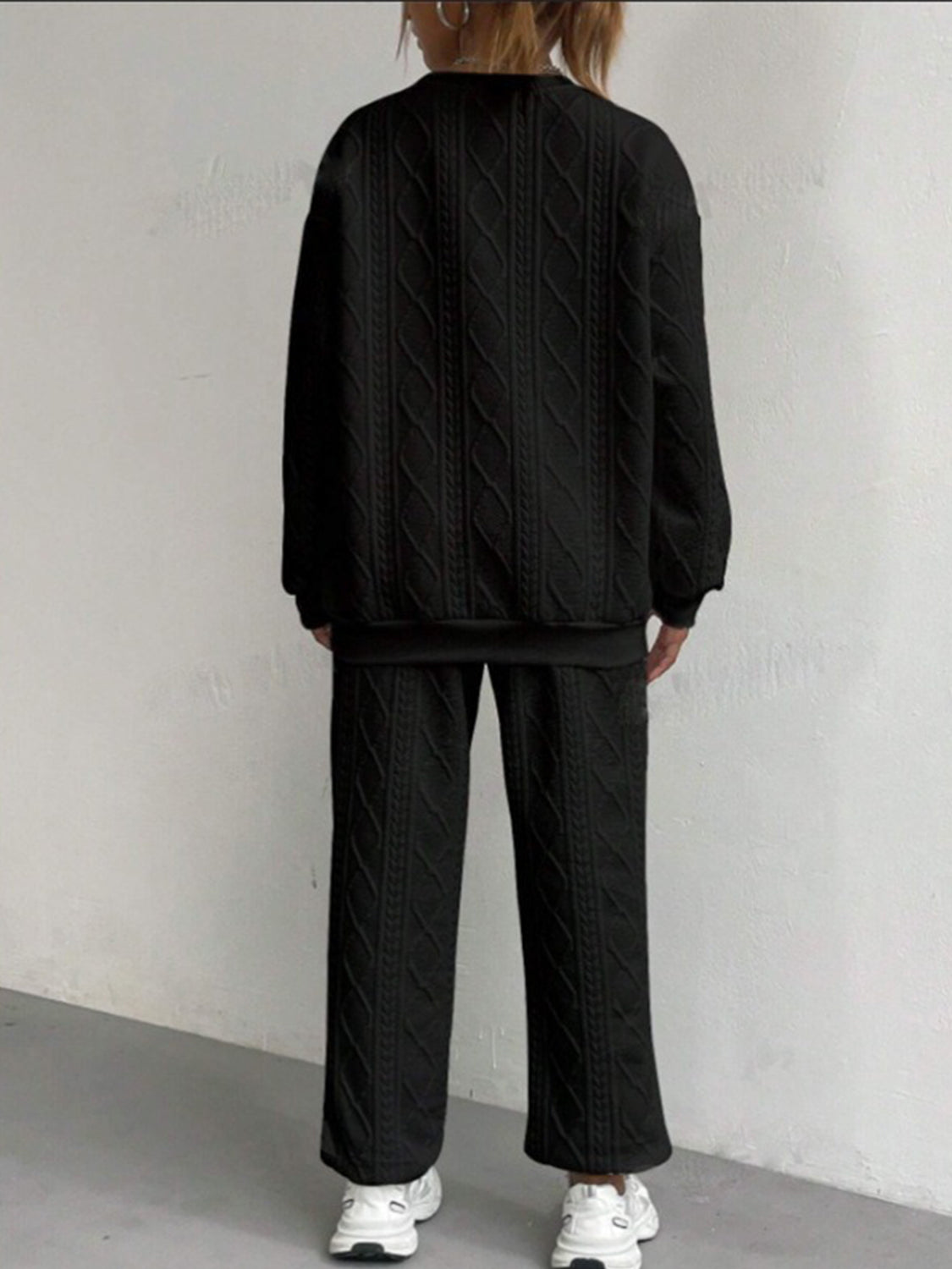 Black cable knit loungewear set with crewneck sweatshirt and wide-leg pants.