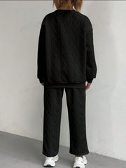 Black cable knit loungewear set with crewneck sweatshirt and wide-leg pants.
